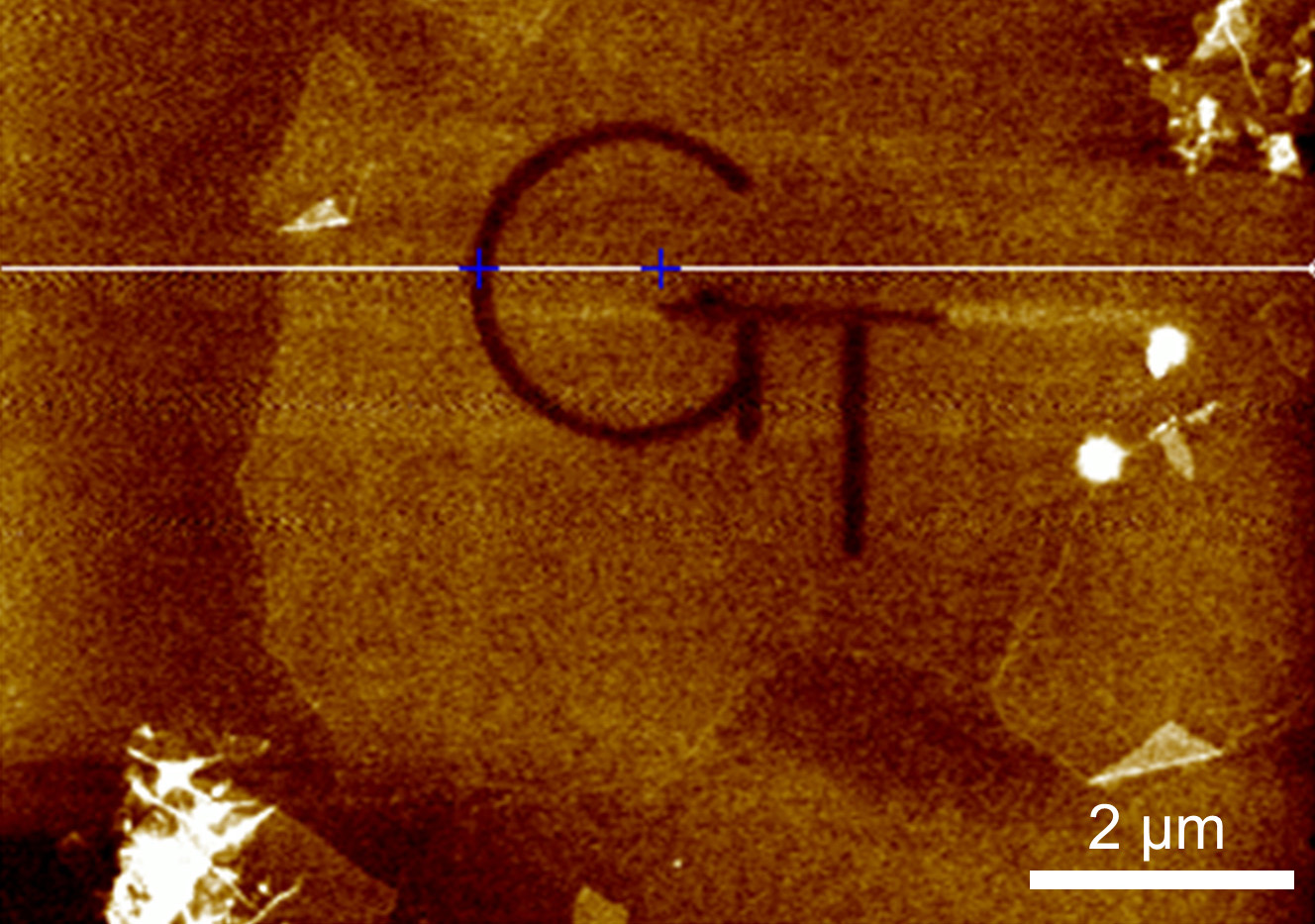 Image shows patterned etching of graphene oxide flakes to create a logo. The etching achieved a depth of 0.9 nanometers.