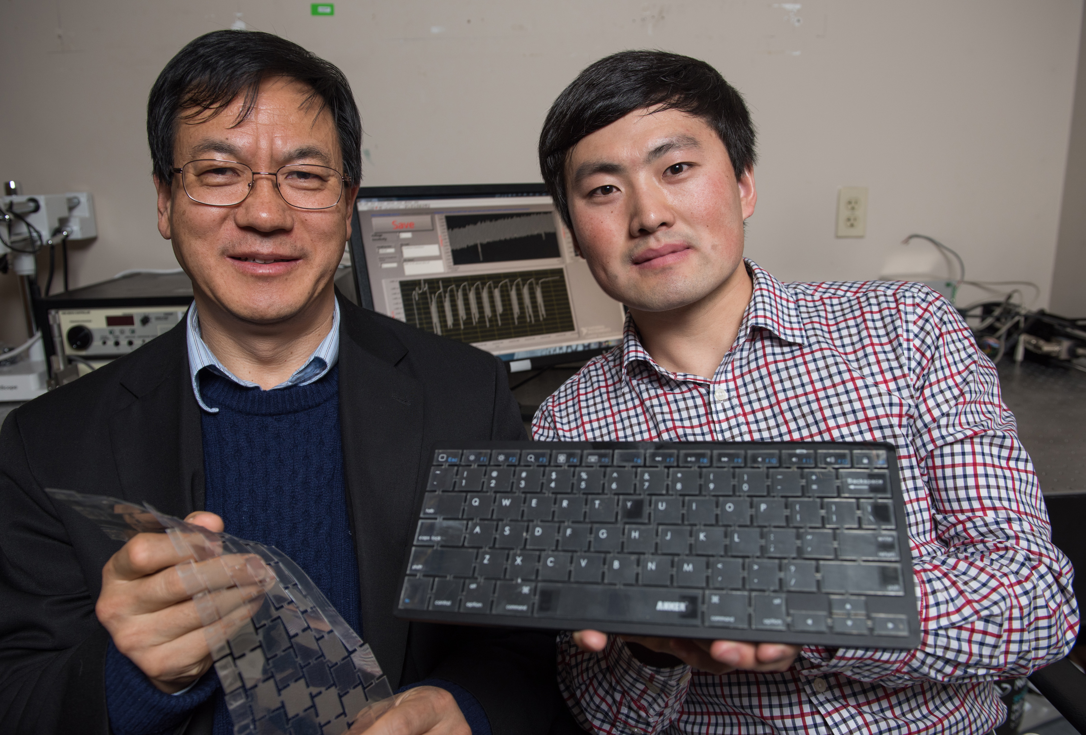 Georgia Tech Professor Zhong Lin Wang (left) and graduate research assistant Jun Chen display their new self-powered keyboard. The device could provide a stronger layer of security for computer users. (Credit: Rob Felt) Georgia Tech Professor Zhong Lin Wang (left) and graduate research assistant Jun Chen display their new self-powered keyboard. The device could provide a stronger layer of security for computer users. (Credit: Rob Felt)