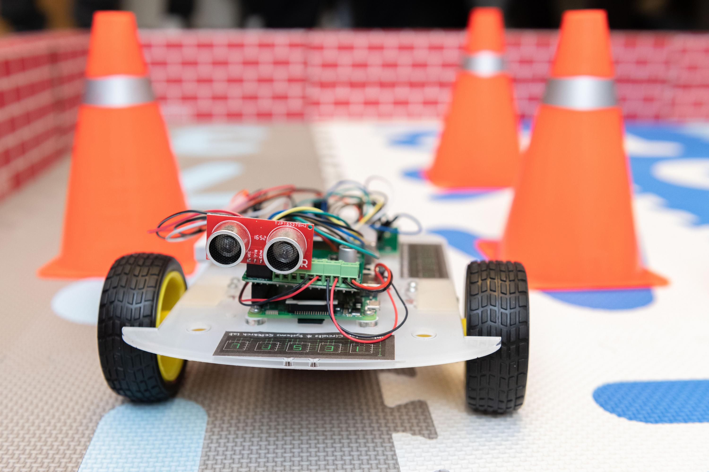 A robotic car controlled by an ultra-low power hybrid chip is shown in an arena to demonstrate its ability to learn and collaborate with another robot. (Photo: Allison Carter, Georgia Tech)