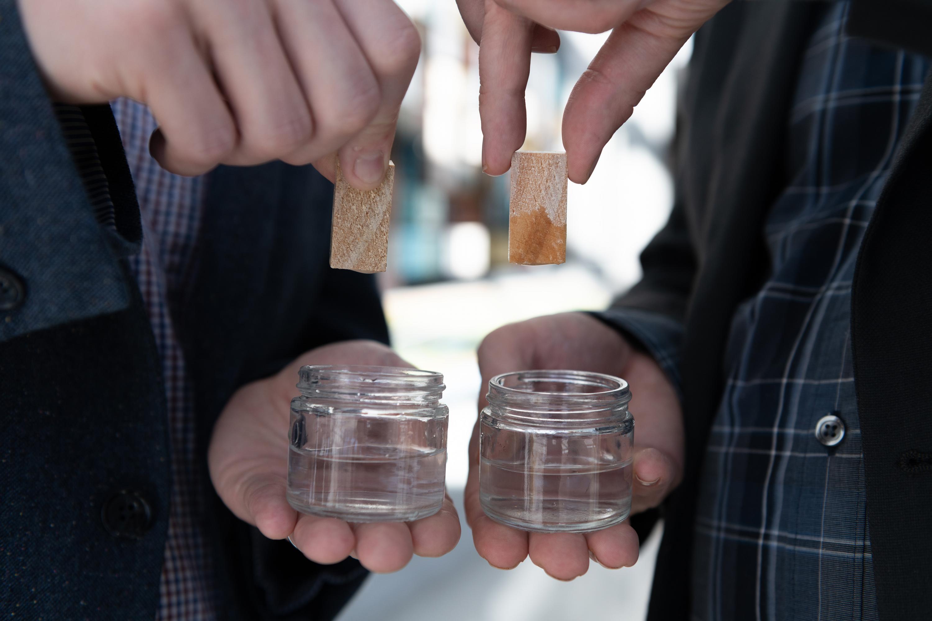 Two pieces of lumber shown after being submerged in water. On the left side is lumber that has been treated using atomic layer deposition and resisted absorbing water. On the right side is untreated lumber that readily absorbs water shown for comparison. (Credit: Allison Carter, Georgia Tech)