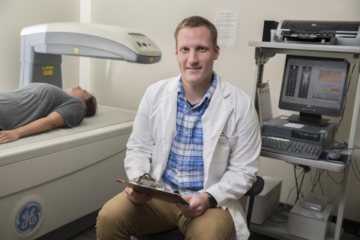 Matt Wittbrodt sits at a device that measures body composition. He is keenly interested in workplace accident risk factors possibly produced by dehydration and exertion and the ensuing decline in physical and cognitive abilities. Wittbrodt received his doctoral degree at Georgia Tech and is a postdoctoral research assistant at Emory University. Credit: Georgia Tech / Christopher Moore