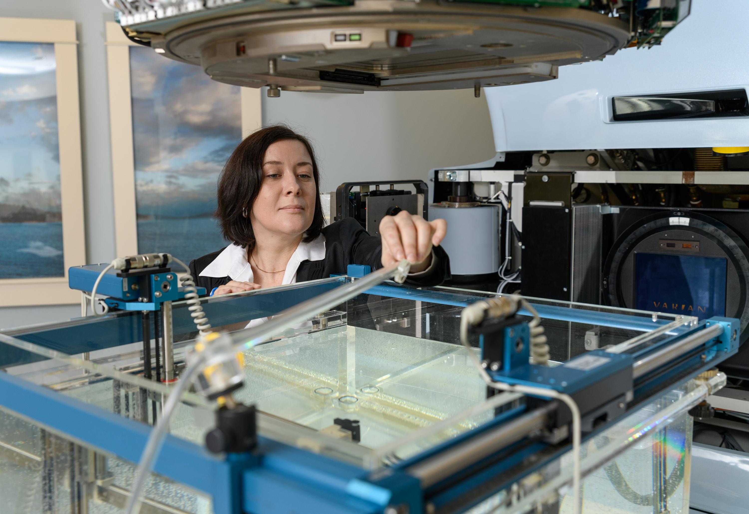 Georgia Tech Associate Professor Anna Erickson positioning a new radiation detector prototype in the Varian Clinac beam to study radiation damage. (Photo: Rob Felt, Georgia Tech)