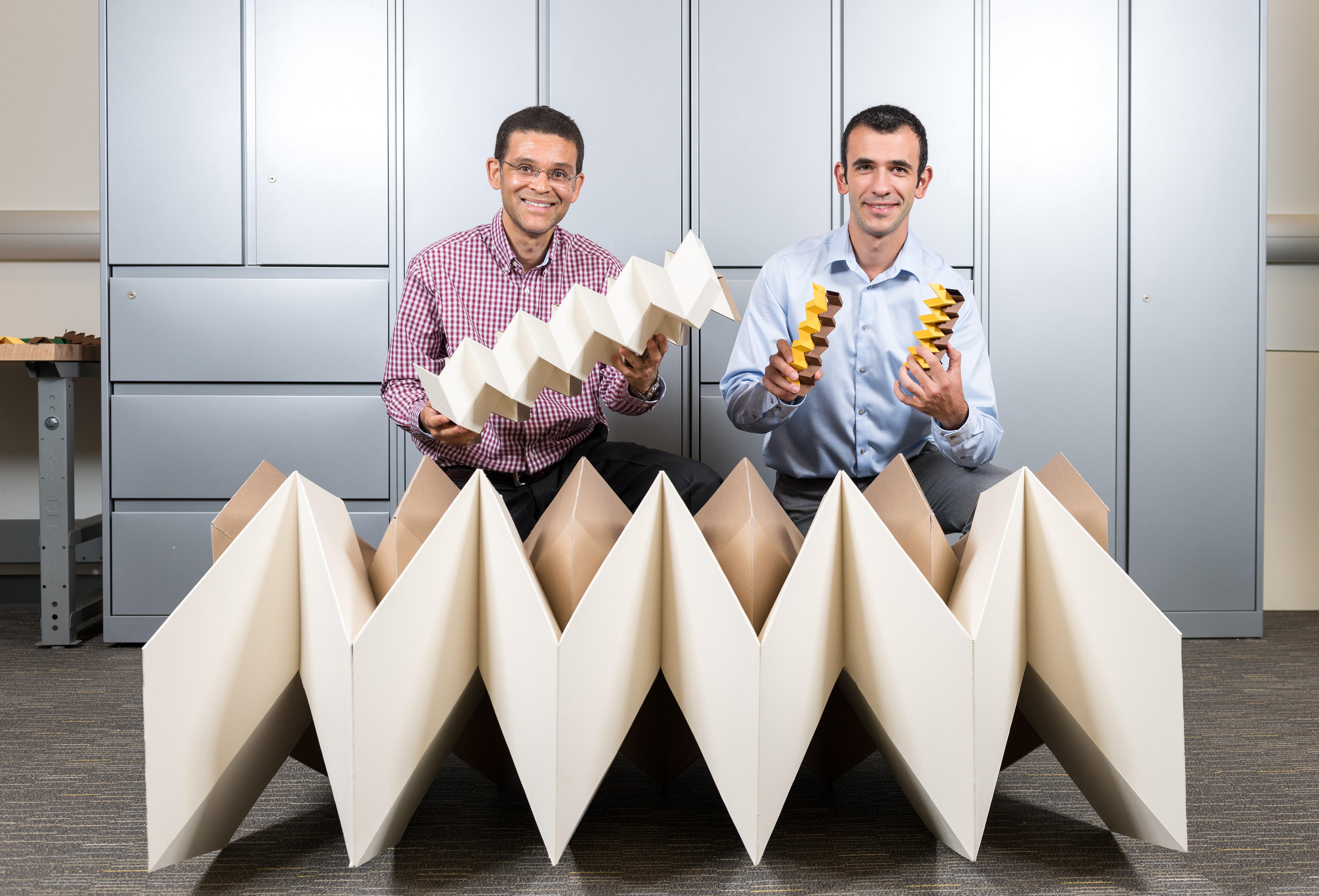 Researchers Glaucio Paulino (left) and Evgueni Filipov with three origami structures showing the size flexibility of the "zippered tube" system. Filipov is from University of Illinois at Urbana-Champaign; Paulino is from the Georgia Institute of Technology. (Credit: Rob Felt, Georgia Tech) Researchers Glaucio Paulino (left) and Evgueni Filipov with three origami structures showing the size flexibility of the "zippered tube" system. Filipov is from University of Illinois at Urbana-Champaign; Paulino is from the Georgia Institute of Technology. (Credit: Rob Felt, Georgia Tech)
