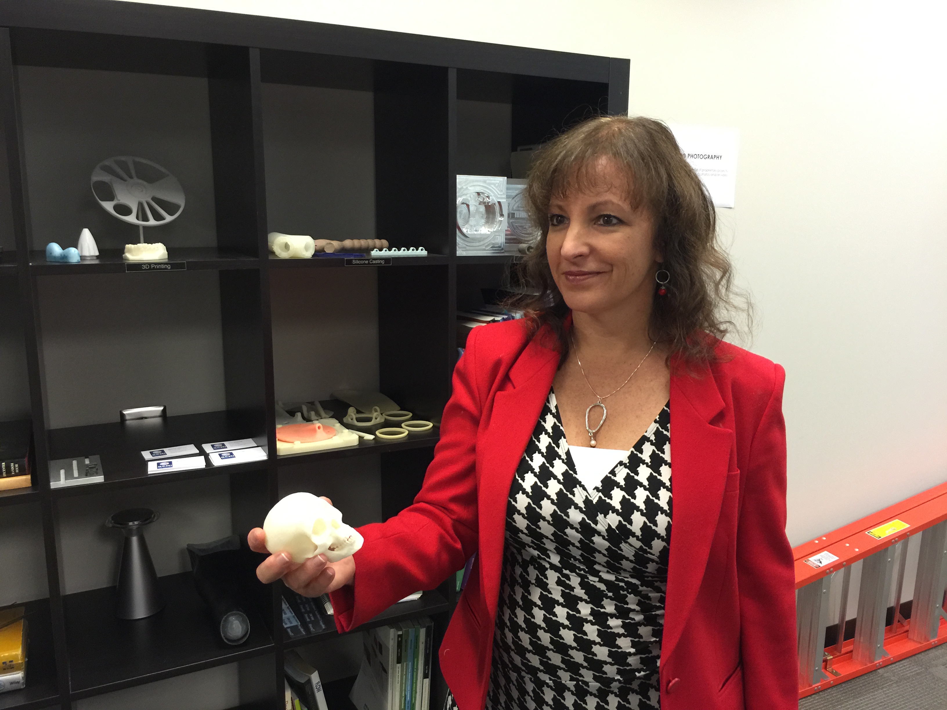 U.S. Commerce Department Office of Innovation and Entrepreneurship Director Julie Lenzer Kirk holds a skull made from a 3D printer at GCMI. The ability to make medical device prototypes is important to companies incubating at GMCI.