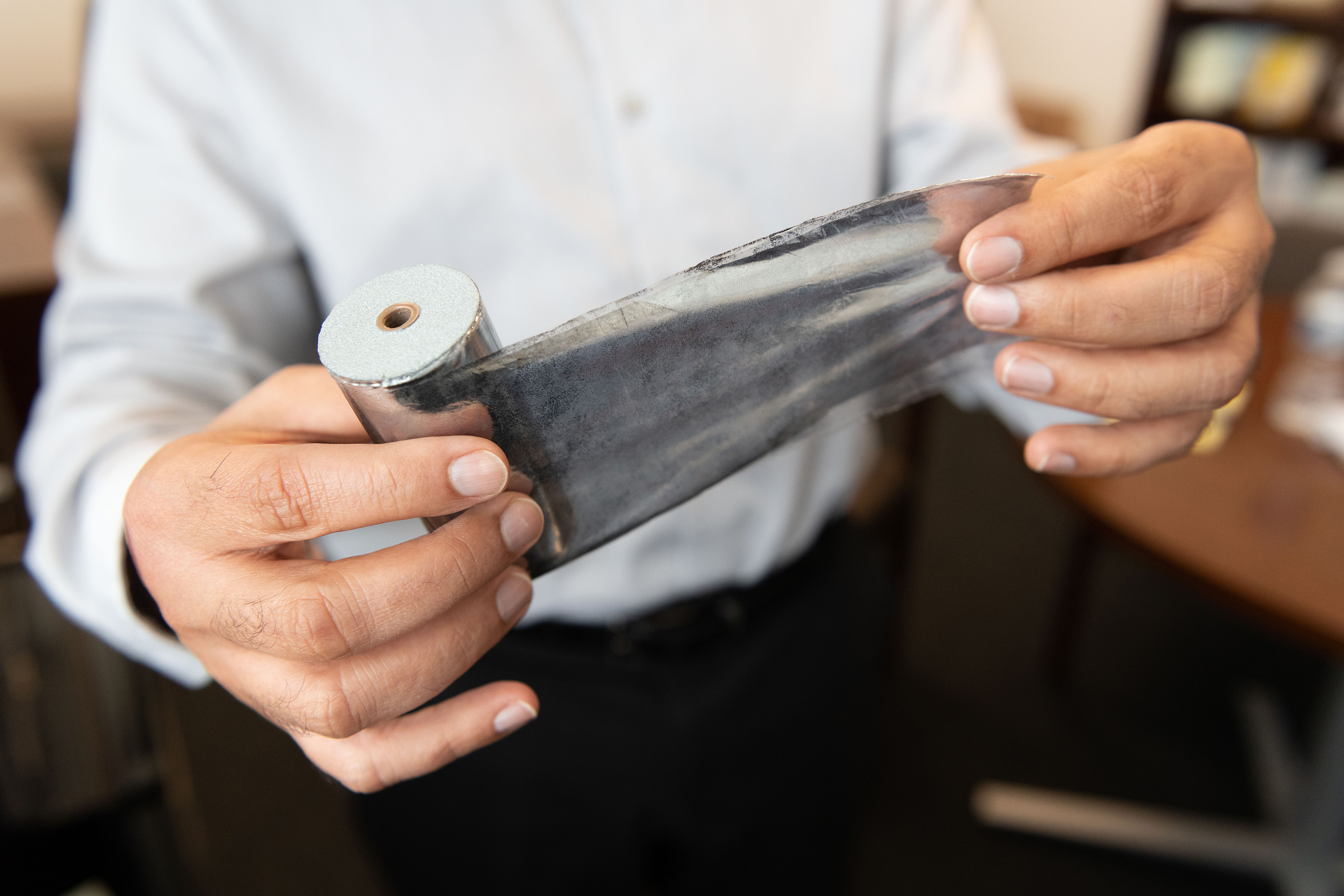 Rampi Ramprasad, a professor in the School of Materials Science and Engineering, holds an aluminum-based capacitor. (Credit: Allison Carter)