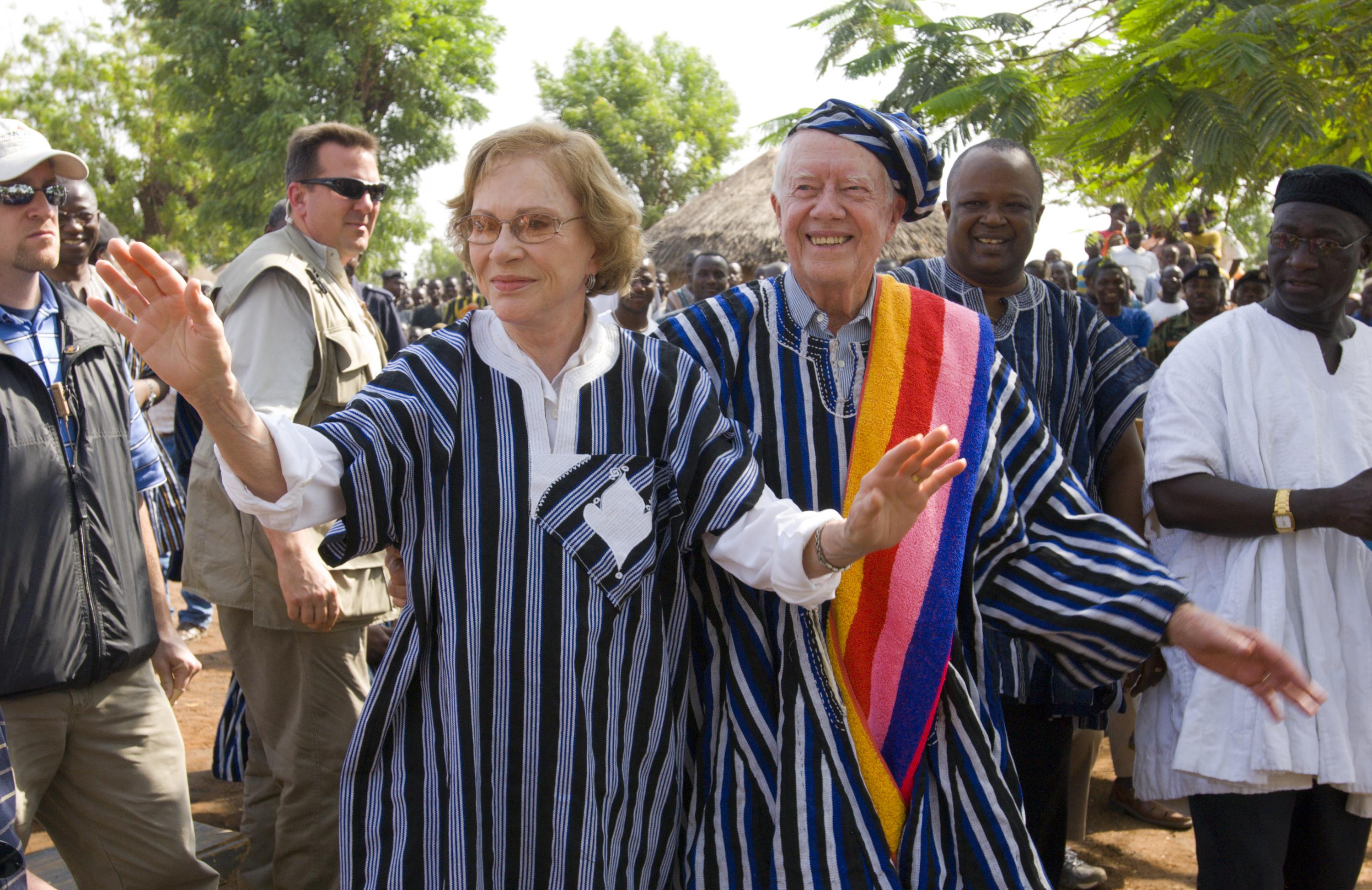 Former U.S. President Jimmy Carter and former First Lady Rosalynn Carter wear traditional Ghanaian attire, a gift from the chief of Tingoli village in northern Ghana, where The Carter Center, in partnership with Ghana's Ministry of Health, worked to eradicate Guinea worm disease and eliminate trachoma. The Carters visited the village Feb. 8, 2007, as part of a two-week health tour of remote African villages. Photo credit: The Carter Center.