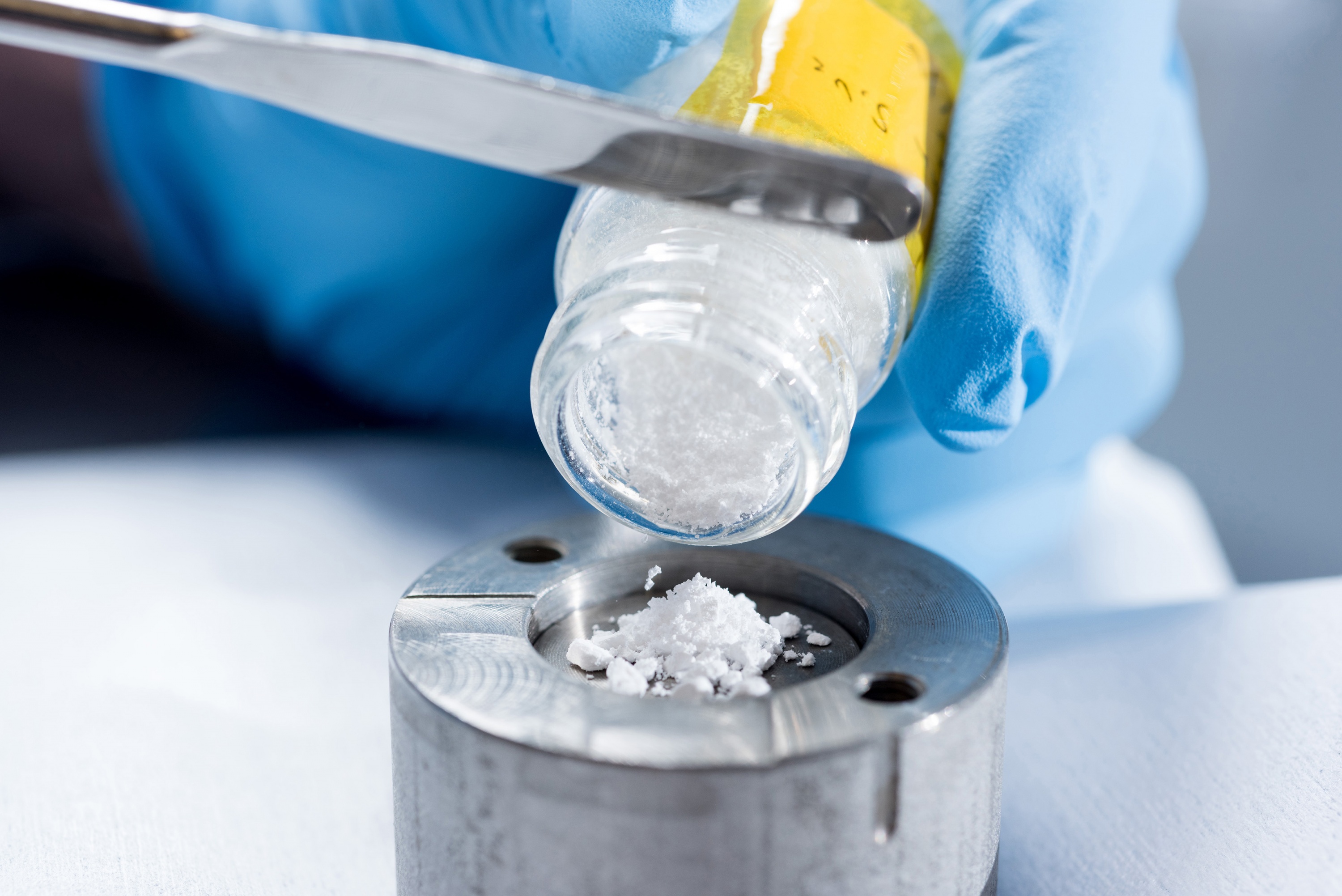Silicon dioxide nanoparticles are poured into test cylinder to study how the unique surface properties of the coated nanoscale material help it conduct heat at potentially higher efficiency than existing heat sink materials. (Credit: Rob Felt, Georgia Tech)