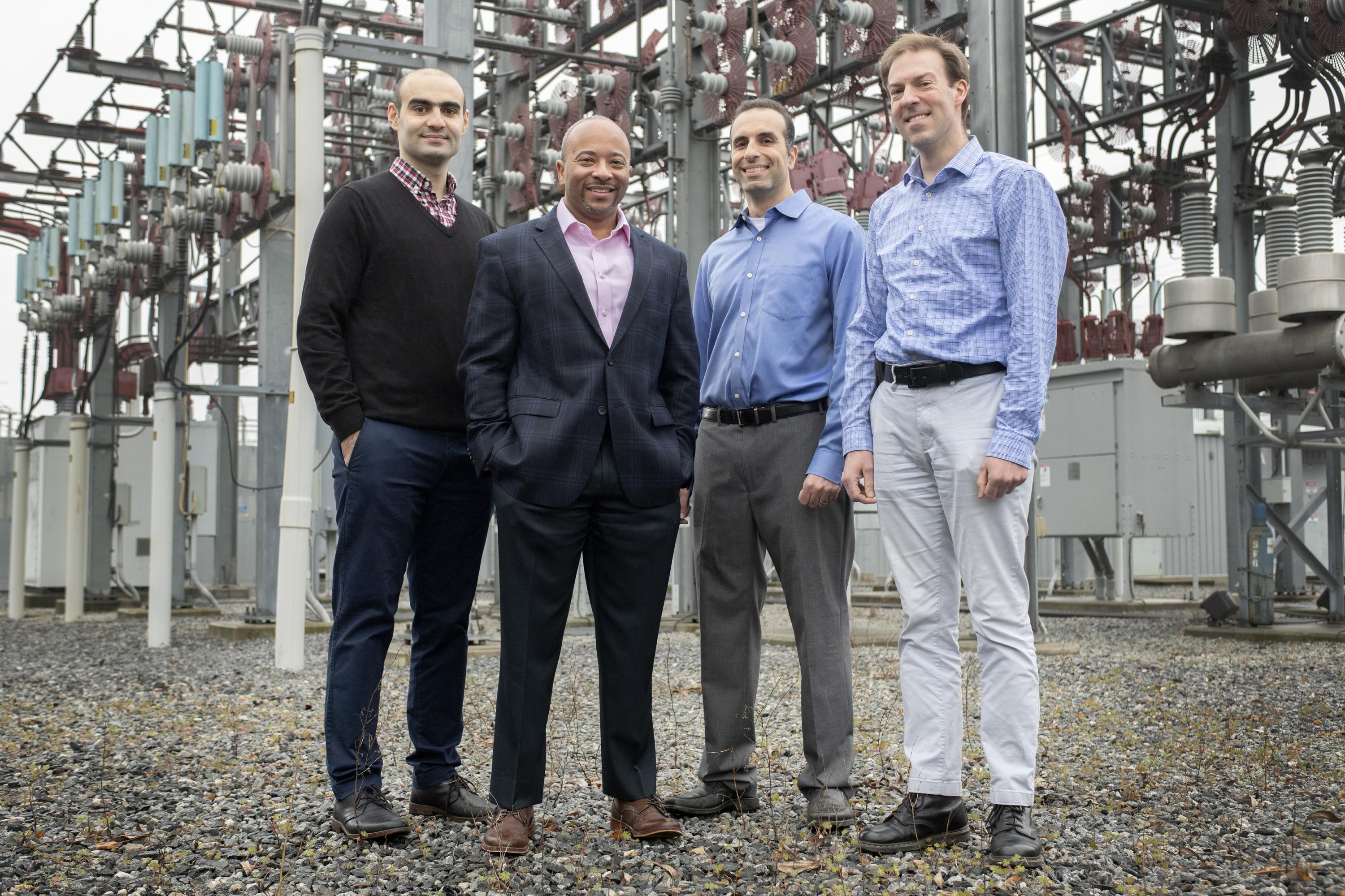 Georgia Tech researchers Tohid Shekari, Raheem Beyah, Morris Cohen, and Lukas Graber are shown with a substation that is part of the electric grid. The researchers have developed a new technique to secure the substations. (Image: Christopher Moore, Georgia Tech)