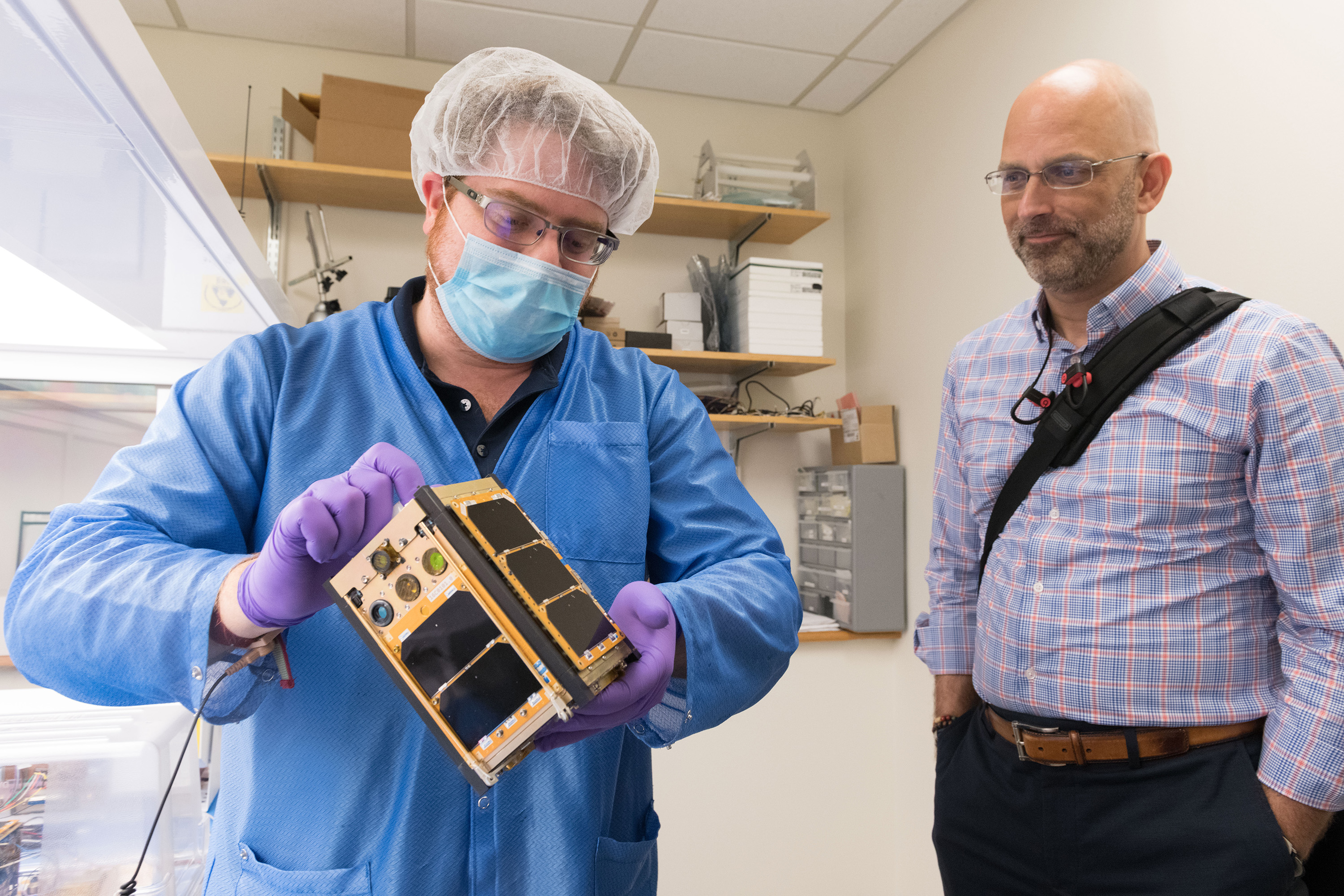 Georgia Tech aerospace engineering graduate student Byron Davis shows Xenesis CEO Mark LaPenna one of the RANGE CubeSats scheduled to go into orbit later this fall. (Credit: Allison Carter, Georgia Tech)